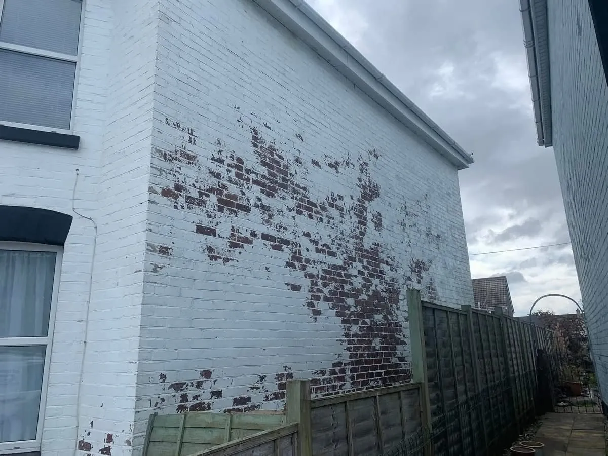Peeling paint on a brick wall before redecoration in Newton Abbot